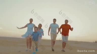 斯坦尼康拍摄的<strong>幸福</strong>的家庭在海滩上，父母和祖父母跑小男孩，让他