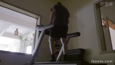 斯坦尼康低角度拍摄的一个成熟的人在跑步机上锻炼，在酒店的低速健身房工作
