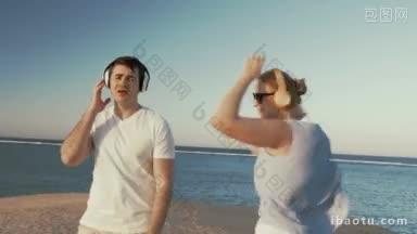 斯坦尼康拍摄的年轻男人和女人在无线耳机走在海滩上，他们唱歌和跳舞的最爱