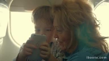 开心的奶奶把小孙子抱在腿上，看着一家人如何用智能手机乘飞机旅行