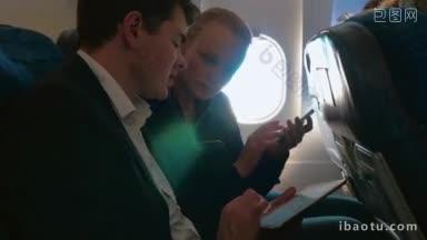 年轻人乘飞机旅行，谈论生意上的事情，男人用平板电脑向女人解释<strong>一些</strong>东西