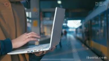 一个女孩在火车站使用笔记本电脑的特写<strong>镜头</strong>，<strong>背景</strong>是人们正在上火车