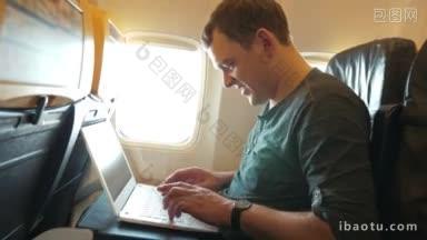 年轻快乐的男子在飞机上用笔记本电脑打字，<strong>看</strong>着<strong>灯</strong>，等待答复
