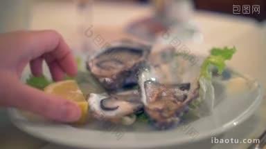 <strong>特写</strong>镜头倒柠檬汁在开放的牡蛎在餐厅美味的海鲜