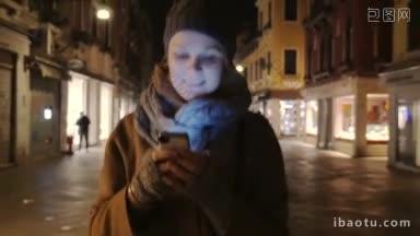 斯坦尼康拍摄的一个女孩走在街上，在晚上和智能手机聊天，然后她把它带走