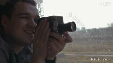 年轻人乘火车旅行，他使用复古摄像机拍摄视频，然后从窗口欣赏风景
