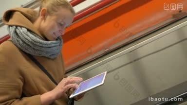 地铁里的一名女子在上电梯时用触控板打字和发送信息