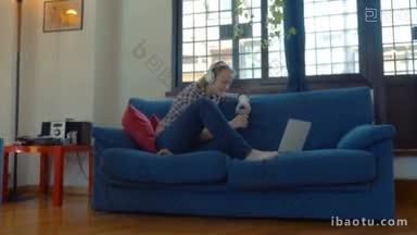 斯坦尼康拍摄的年轻女子戴着耳机坐在沙发上的笔记本电脑和视频聊天