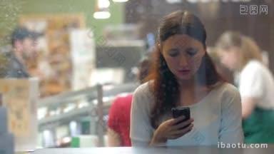 透过咖啡馆的玻璃，一名年轻女子正在用手机打短信或在<strong>社交网络</strong>服务上聊天