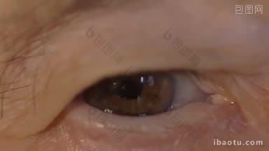 慢动作和极端特写镜头，一个眨眼的棕色眼睛的老年妇女的皱纹<strong>皮肤</strong>