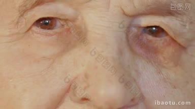 特写的一张老年妇女的脸，疲惫的棕色眼睛和皱纹的<strong>皮肤</strong>