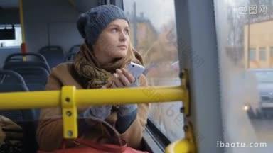 一个女人在沉闷的日子里坐在<strong>公交</strong>车上，她正在用智能手机写东西的慢镜头