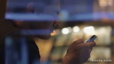 一个男人的慢镜头，他把智能手机放在玻璃后面，在晚上浏览<strong>社交</strong>网络服务