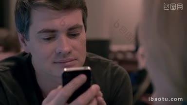慢镜头:在咖啡馆见面时，年轻男子用智能<strong>手机</strong>向女子播放视频