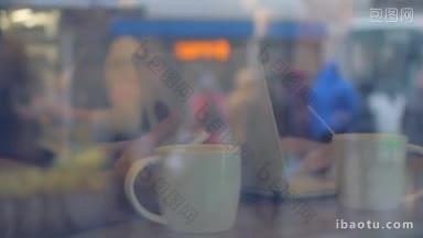慢动作的男人和女人使用智能<strong>手机</strong>和笔记本电脑，在咖啡馆喝茶，反映城市