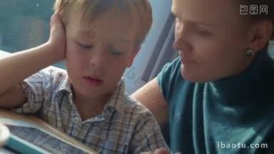 快乐的一家人坐火车旅行，<strong>妈妈</strong>和玩平板电脑的小儿子聊天，他们互相亲吻