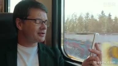 年轻的商人戴着眼镜在火车上用智能<strong>手机</strong>视频聊天