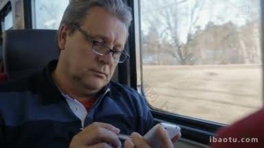 戴眼镜的老人在火车上用钢笔和智能手机上网打发时间