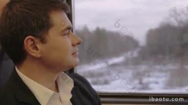 一个穿着西装的年轻人坐在<strong>火车车厢</strong>里，望着窗外沉思着