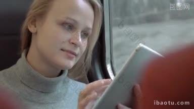 年轻女子坐在<strong>火车车厢</strong>靠窗的地方，她微笑着在她的平板电脑上打字
