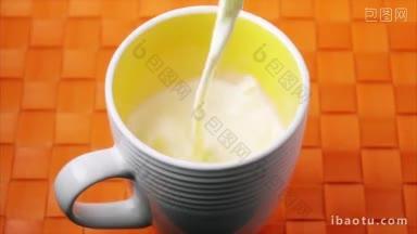 特写的杯子被装满牛奶为早餐高<strong>角</strong>视<strong>角</strong>的液体飞溅在橙色背景