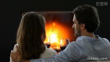 幸福的夫妇在壁炉旁碰杯