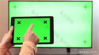 一名女子一边看电视，一边拿着绿色屏幕的平板电脑设备敲击