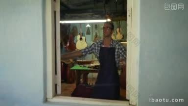 琵琶制作店和古典乐器年轻的成年工匠开他的店，他修复了一个旧的古典吉他缺乏