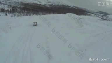 空中越野在阴沉的阴天在雪路上驾驶汽车在冬季山区旅行