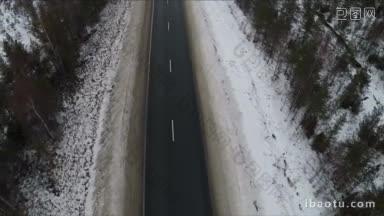 在冬天没有汽车的路上，北方的土地被雪覆盖，路上有罕见的树木