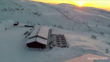 滑雪胜地木屋的航拍照片，背景是升起的太阳