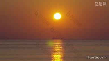 夕阳西下，海上<strong>货船</strong>和帆船在远处金色的阳光反射在寂静中