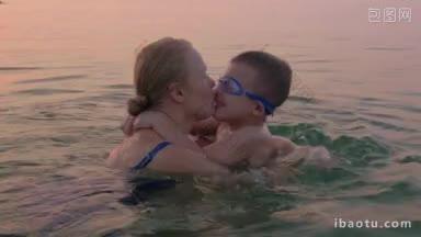 夕阳西下，在海里游泳的母子互<strong>相拥</strong>抱亲吻