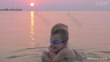 一家人在海边度假，兴高采烈的儿子和年轻的母亲在日落时在海里沐浴