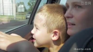 年轻的母亲和小儿子通过一辆行驶的汽车的窗户<strong>看城市</strong>的特写<strong>镜头</strong>很有趣