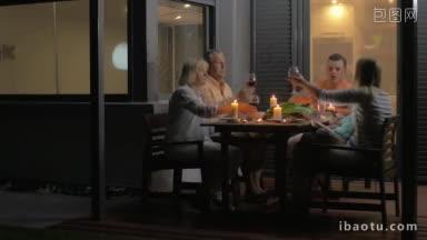 一家人坐在阳台上碰杯吃饭的特写镜头