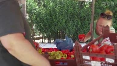 年轻女子在街头摊贩挑选西红柿，把它们放进<strong>袋子</strong>里，交给卖家测量