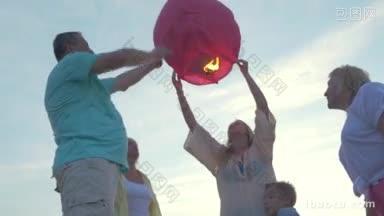 斯坦尼康拍摄的母亲儿子和祖父母放飞纸灯笼在夏天的一天与以下观点灯笼得到