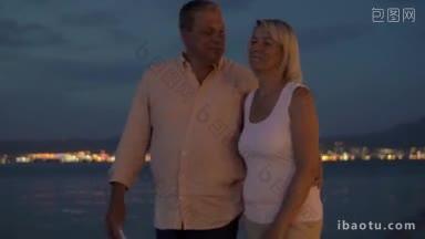 成熟的夫妇在海滩上散步，用智能<strong>手机</strong>自拍的斯坦尼康镜头拍摄的安静的晚上在避暑胜地