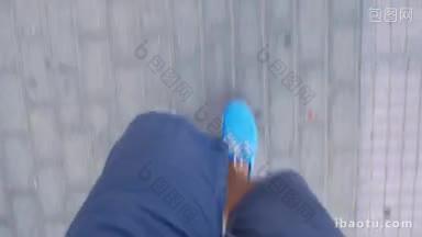 一个穿着短裤和亮蓝色鞋子的人沿着铺好的人行道<strong>俯视</strong>图走的时间间隔<strong>镜头</strong>