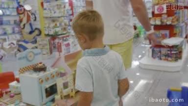 父母和孩子走在超市和玩具炊具<strong>吸引</strong>男孩的注意力好奇的孩子玩玩具