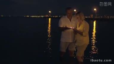 老夫妇晚上站在浅海上，把<strong>蜡烛</strong>放在水面上，看着它们漂浮