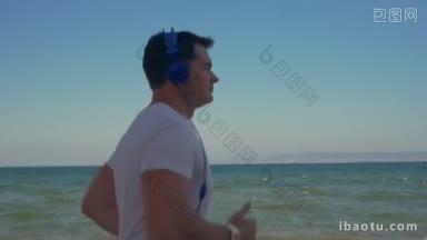 慢动作斯坦尼康拍摄的一个年轻人定期慢跑训练沿海岸，大海和清澈的蓝天