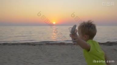 慢<strong>动作</strong>斯坦尼康拍摄的一个小男孩与玩具飞机沿着海滩跑到父母的母亲带他
