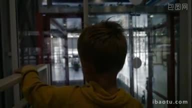 一个小男孩乘坐玻璃<strong>电梯</strong>，然后离开它握着母亲的手现代建筑的慢镜头