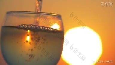 慢动作特写镜头，倒矿泉水到玻璃上的背景大金色的夕阳反射