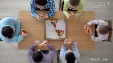 一群不同的人<strong>围坐</strong>在桌子旁吃披萨