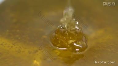 蜂蜜滴在蜂蜜碗上的微距镜头