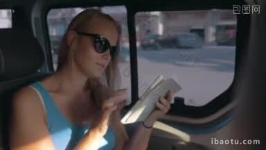 戴着墨镜的年轻女子在<strong>乘车</strong>途中用平板电脑上网