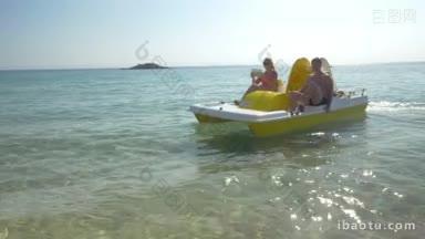 年轻的父母和年幼的孩子在脚踏船水上<strong>游玩</strong>，母亲用垫子自拍